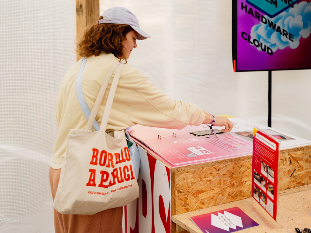 Young person laying their phone on a large display